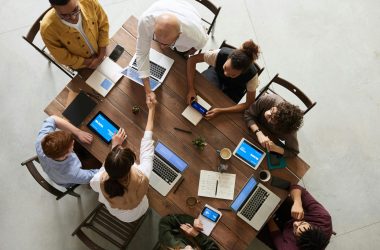 pexels photo 3183197 3183197 Top view of a diverse team collaborating in an office setting with laptops and tablets, promoting cooperation.